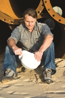 man sitting holding a construction hat
